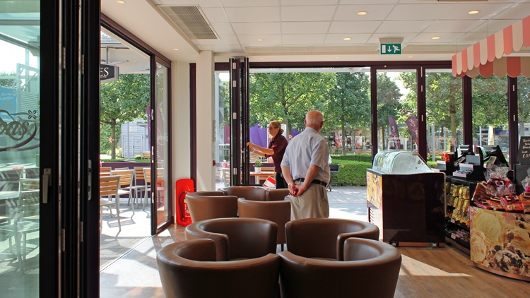 Photo of aluminium bifold doors within a Thorntons cafe, out of town shopping complex
